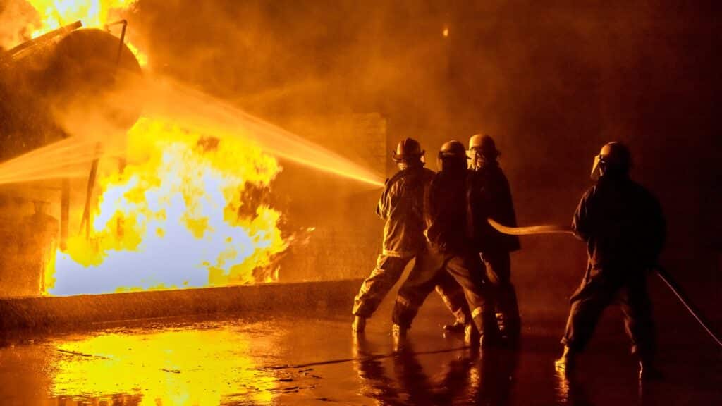 Firefighters rushing into a burning building